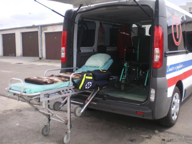 Wysunięte nosze transportowe przy otwartych drzwiach ambulansu