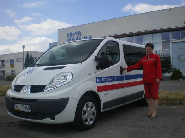 Biały ambulans Renault Trafic z niebiesko-czerwonym oznakowaniem